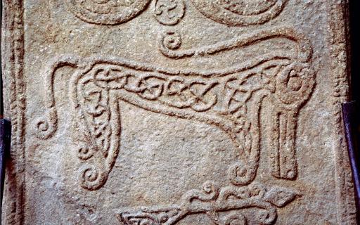 Pictish stones depicts beast with long snout, curled ears and hooked tail. Inscribed with knot designs.
