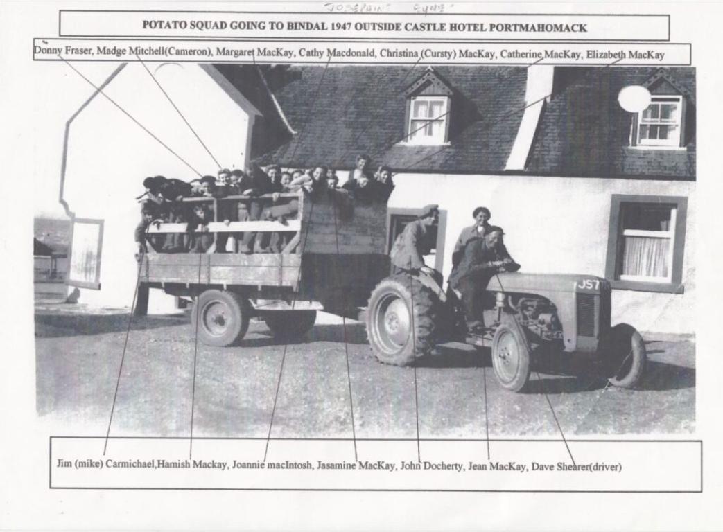 Black and white photograph of the 'Tattie Squad' at Cullisse Farm standing on a wagon attached to small tractor vehicle