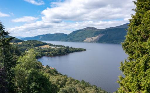 Loch Ness from the shore at Foyers, which is lined by tall, green trees