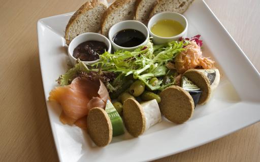 Plate of bread, oils, salad, salmon, cheese and oatcakes.