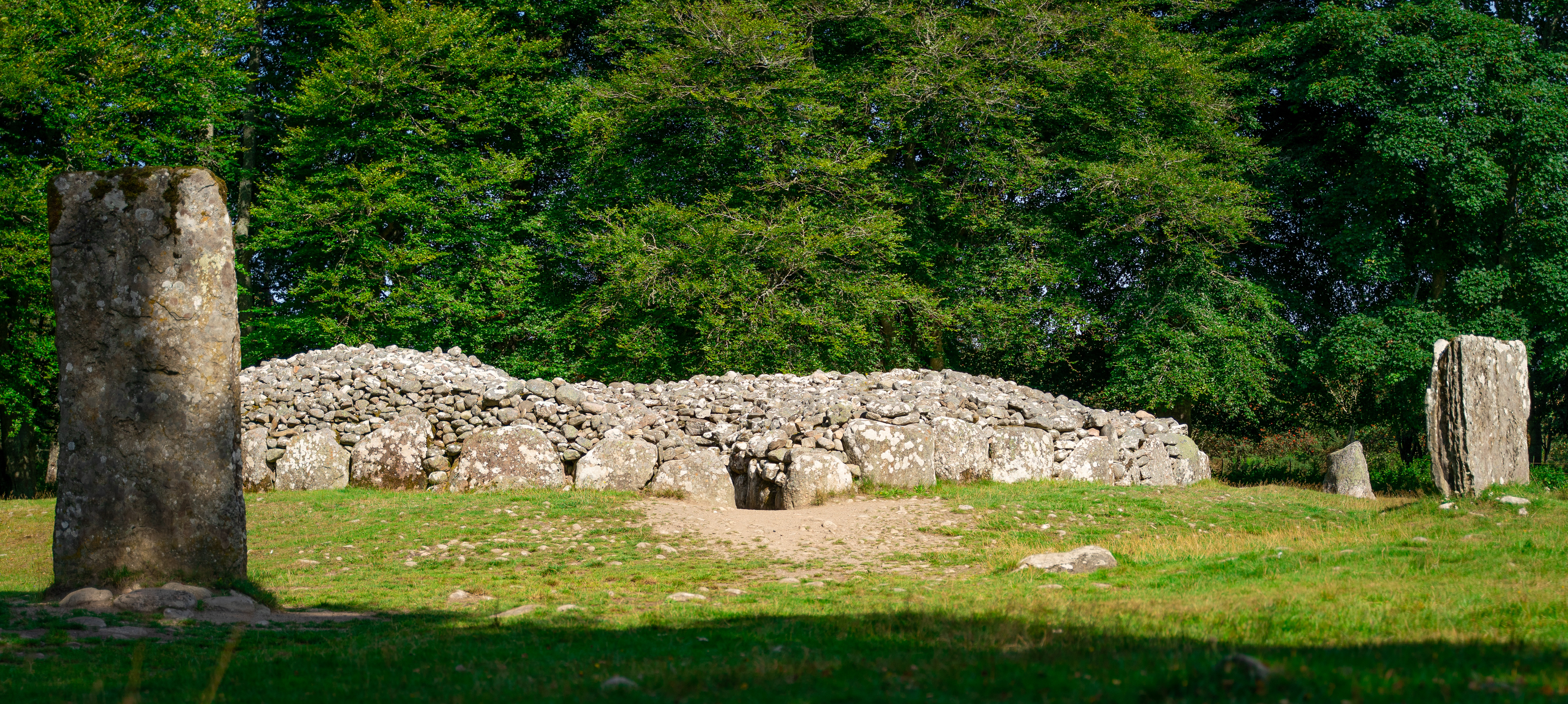 Entrance to the Clava Cairns. The low lying, long cairn is flanked by stone pillars.
