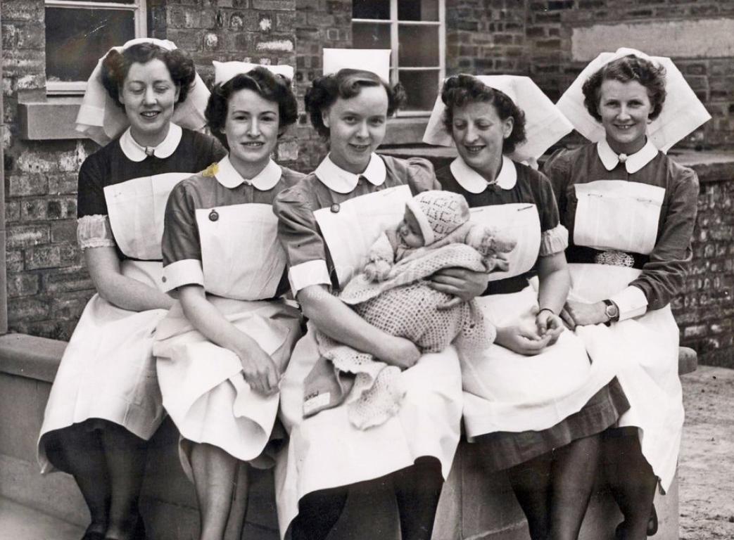 A photograph of a group of nurses at Raigmore Hospital in the 1950s, one of whom is holding a baby.