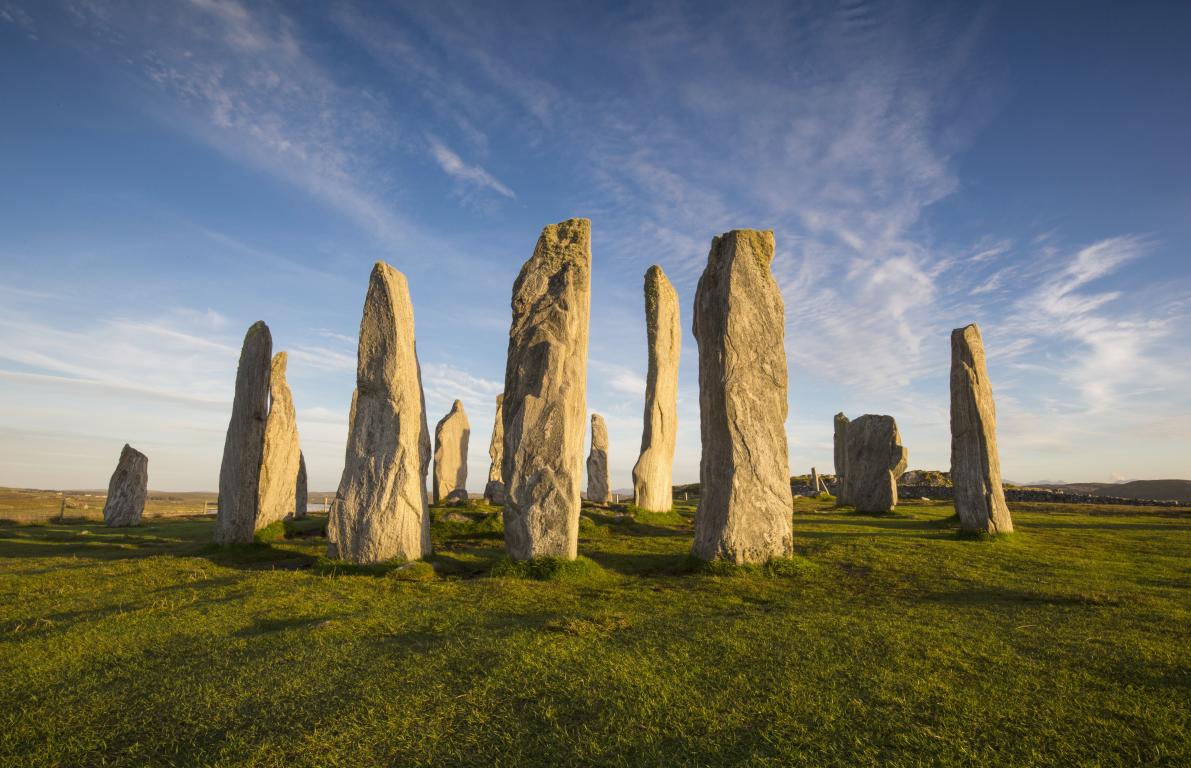 Circle of standing stones in a grassy field.