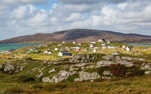 Rocky landscape of Eriskay, with numerous white buildings with slate roofs visible in the center of the image