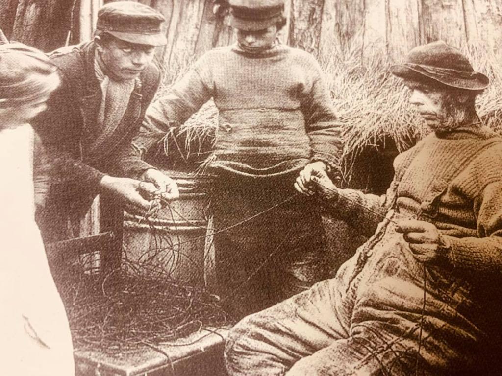 A sepia archive image fishermen from Nairn wearing ganseys and caps