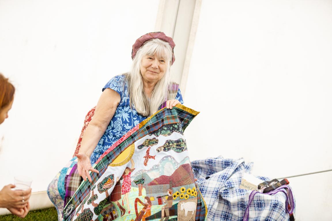 Lizzie McDougall, Spirit:360 artist and storyteller, with her colourful Story Quilt