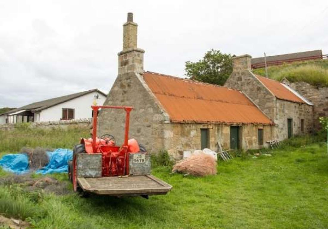Portmahomack Salmon Bothy and Ice House. A red tractor is seen in the foreground