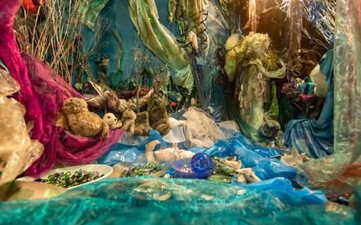 Display made of green, blue and purple material with toy seals and trinkets amongst the folds.