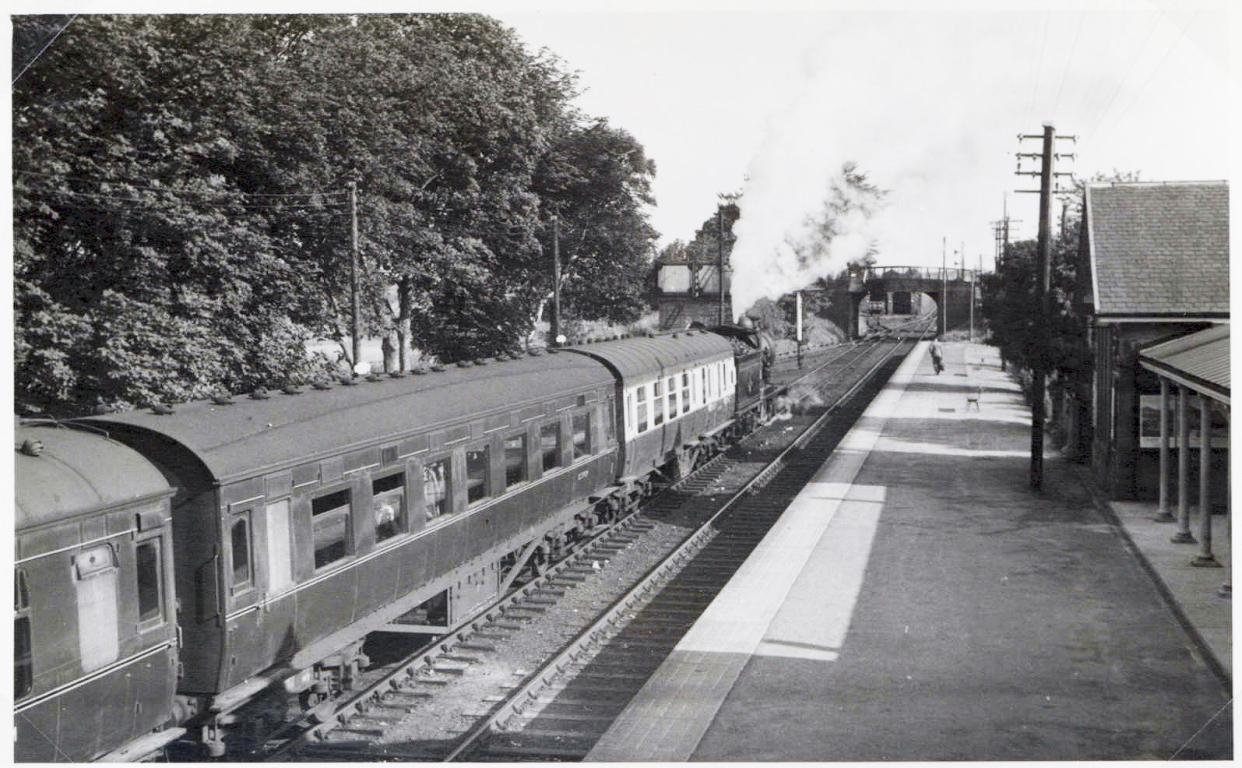 Black and white image of a steam train arriving at Tain Station