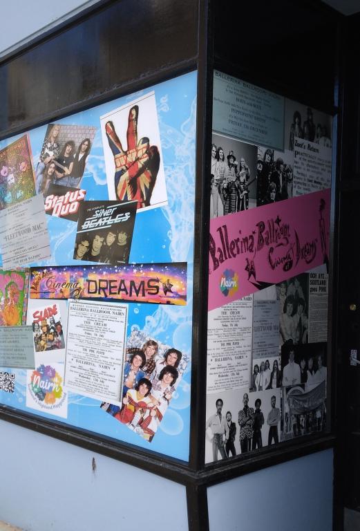 Vinyl stickers in a window feature music and posters.