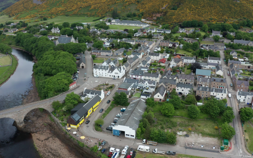 Aerial image of Helmsdale streets lined with houses and start of harbour sheds.