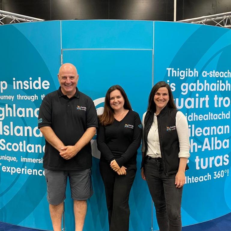The Spirit of the Highlands team standing in front of blue circular immersive pod