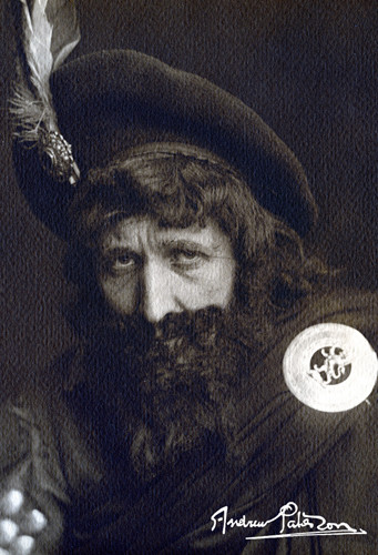 Black and white photograh of Tom Snowie . Snowie is dressed for his character of Rob Roy, with a large clan pin on a scarf by his left shoulder and in a large hat with a feather attached to the center
